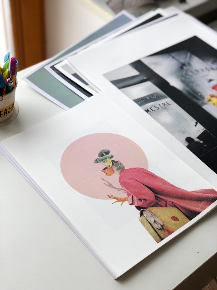 An artistic display of creative photographs and artwork on a desk, featuring vibrant colors and modern design.